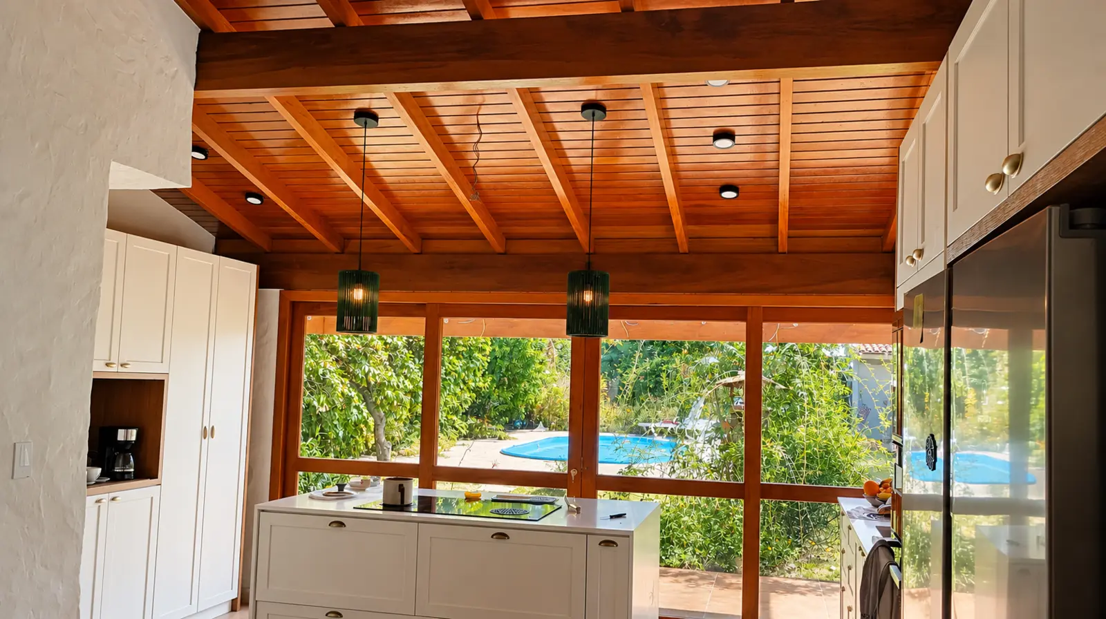 Cozinha com acabamento claro e vista para o jardim